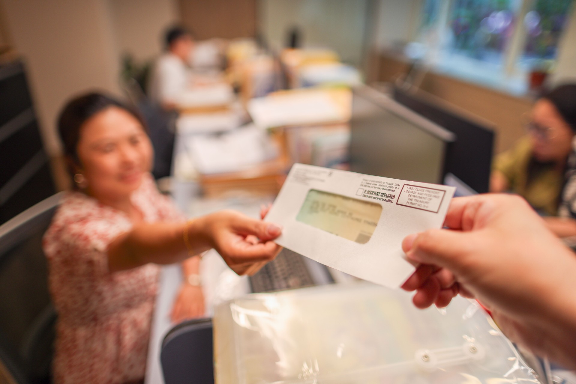 Woman receiving tax refund check from government in office